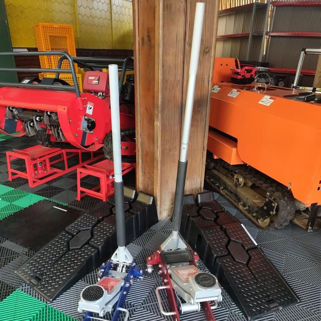 Showroom Agri Bat Mat : motoculteur rouge, transporteur chenillé orange, crics rouleurs et rampes